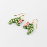 Boucles d'oreilles cacatoès sur feuilles de bananier