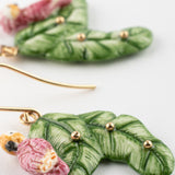 Boucles d'oreilles cacatoès sur feuilles de bananier