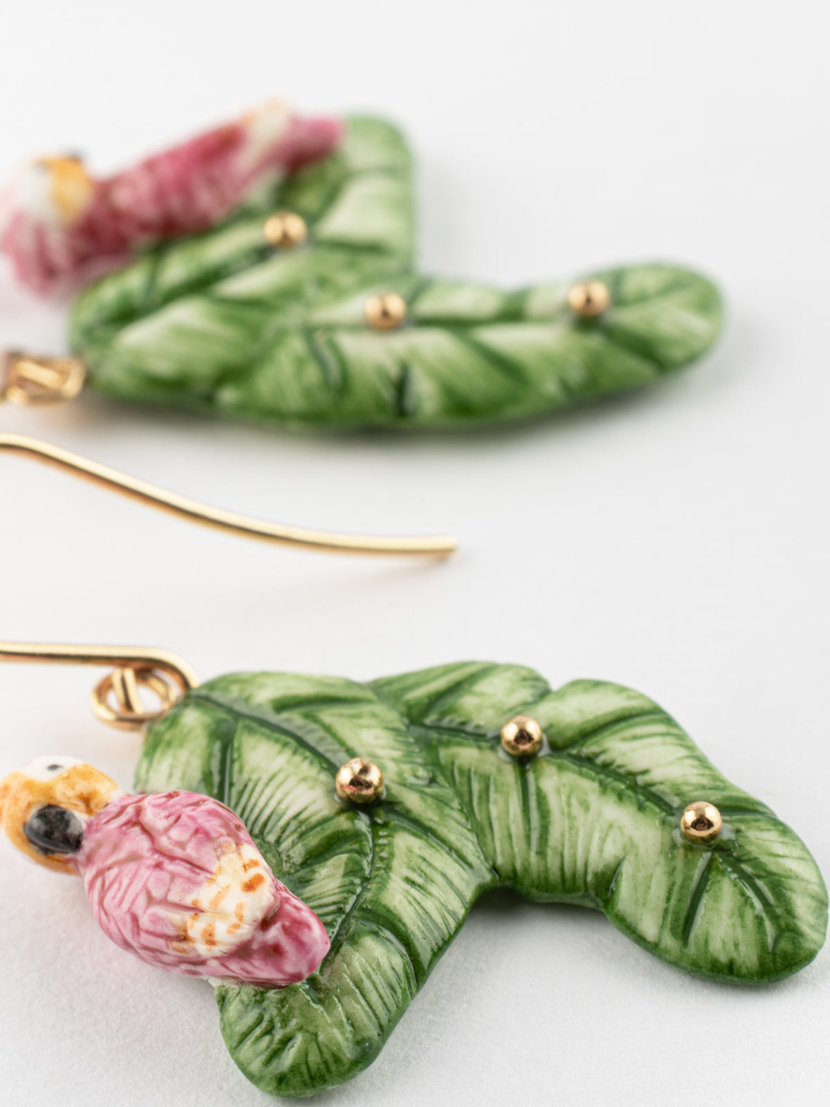 Boucles d'oreilles cacatoès sur feuilles de bananier