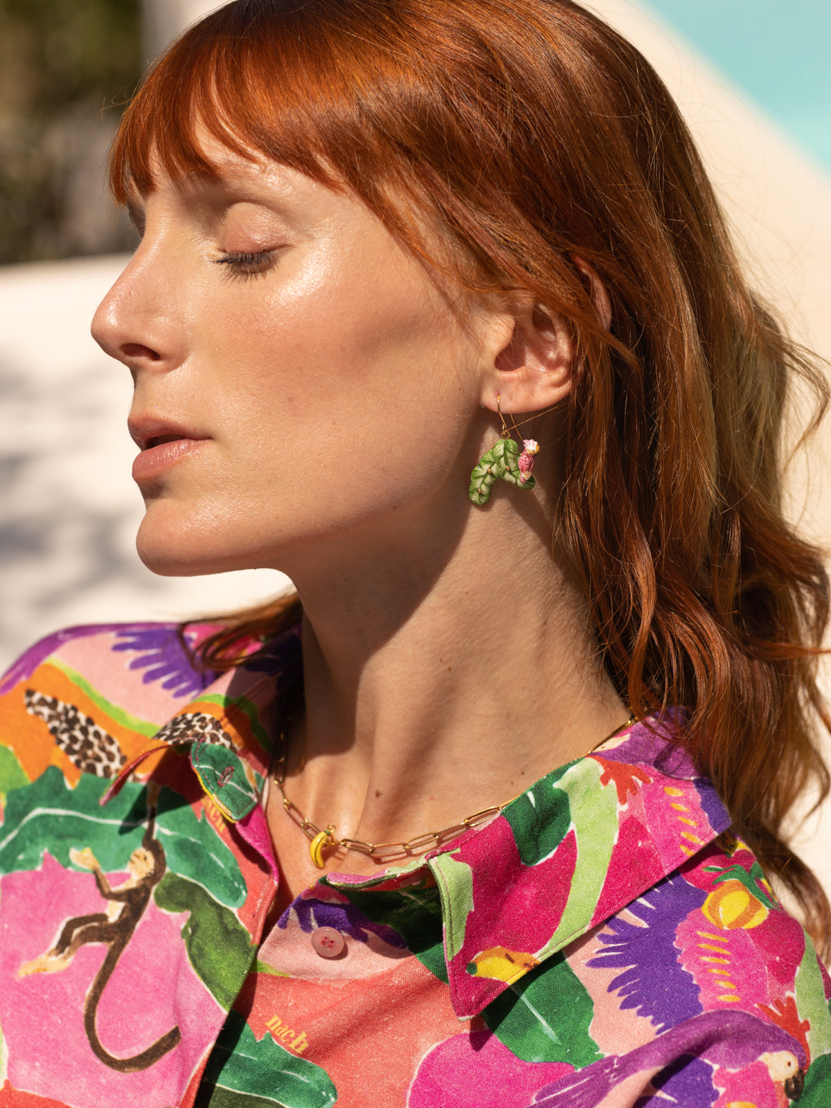 Boucles d'oreilles cacatoès sur feuilles de bananier