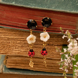 Boucles d'oreilles pendantes dorées fleur et coccinelle