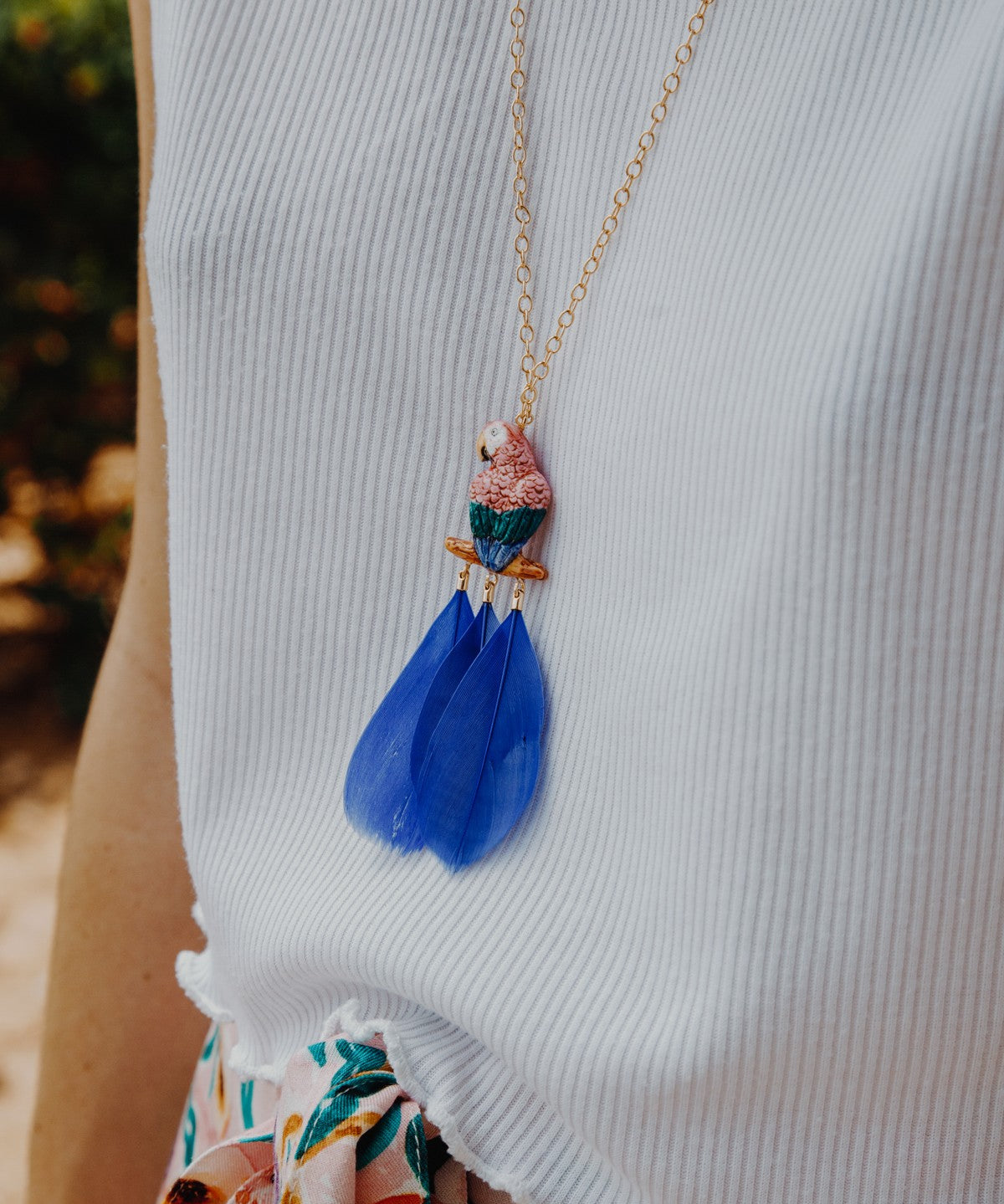 collier doré perroquet rose bleu plume bleue