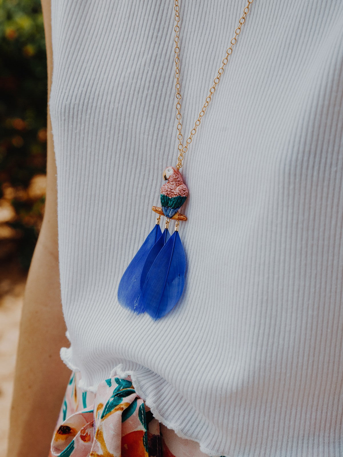 collier doré perroquet rose bleu plume bleue