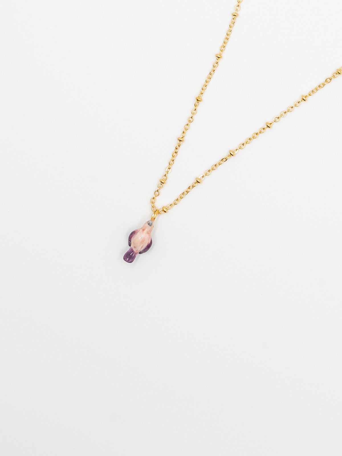 collier doré oiseau perroquet rose