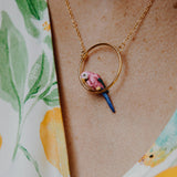 collier rond doré perroquet rose et bleu